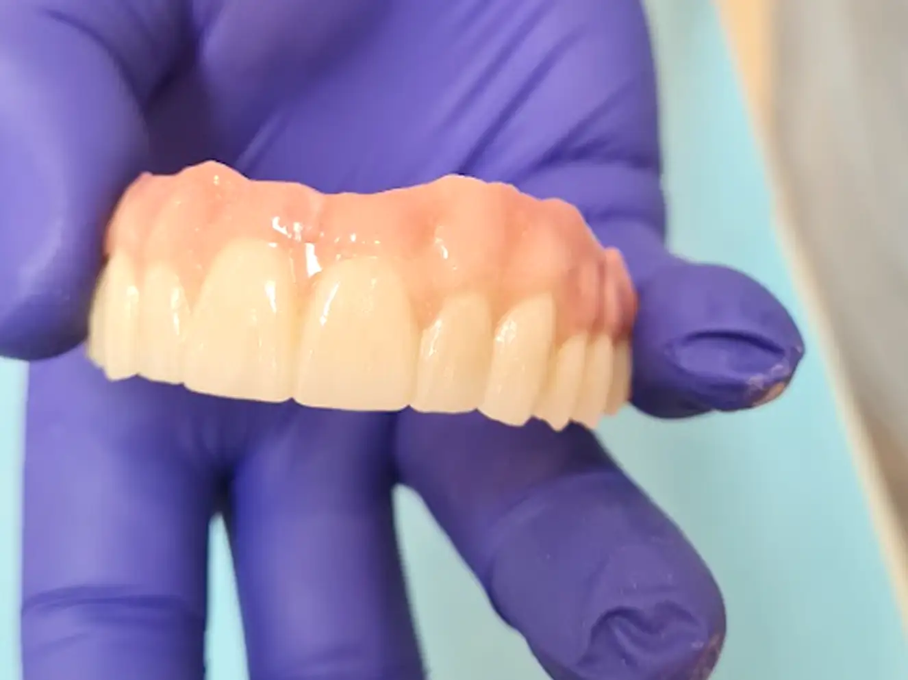 Muestra dentadura completa en mano de odontólogo